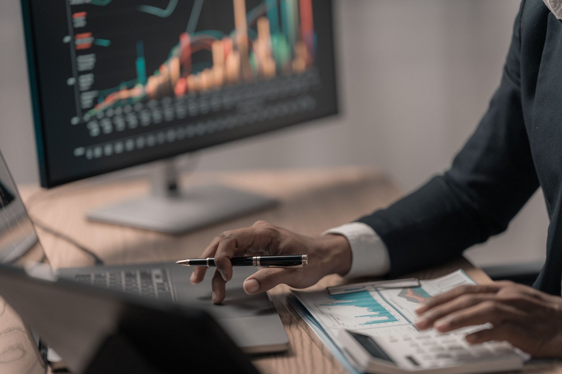 Businessman analyzes growth charts on laptop for financial insights using tablet and laptop to analyze financial charts. Investment strategies for near-term stock market growth
